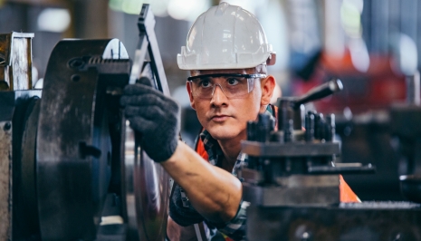 blue collar guy in a hard hat working on a machine