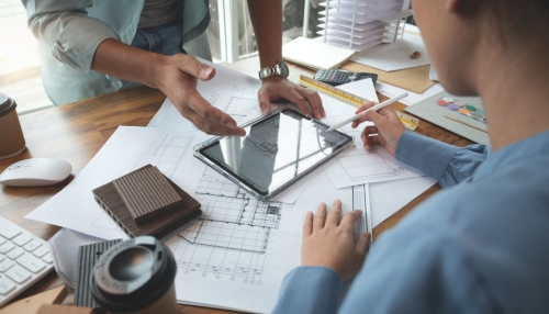 two people reviewing plans on an pad device